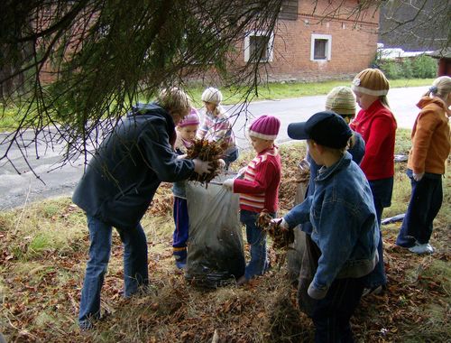 Dzieci podczas akcji grabienia i zbierania lici