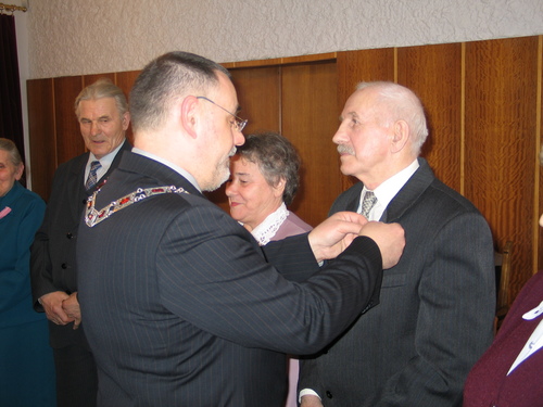 Wrczenie medali. Burmistrz Brus, Jerzy Fijas odznacza medalem za dugoletnie poycie maeskie Wadysawa Stpr