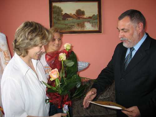 Burmistrz Brus wrcza Pani Magorzacie Wera list gratulacyjny i kwiaty.