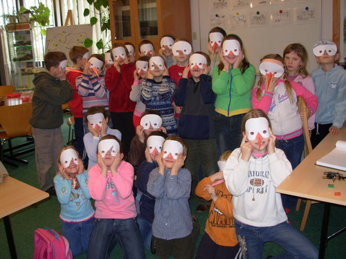 Modsi uczniowie w wykonanych przez siebie maskach bociana